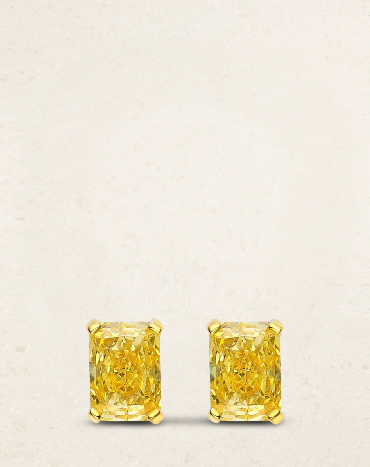 Radiant cut fancy yellow stud earrings, 1 carat each, set in sterling silver with gold prongs – elegant bridal or evening jewelry.