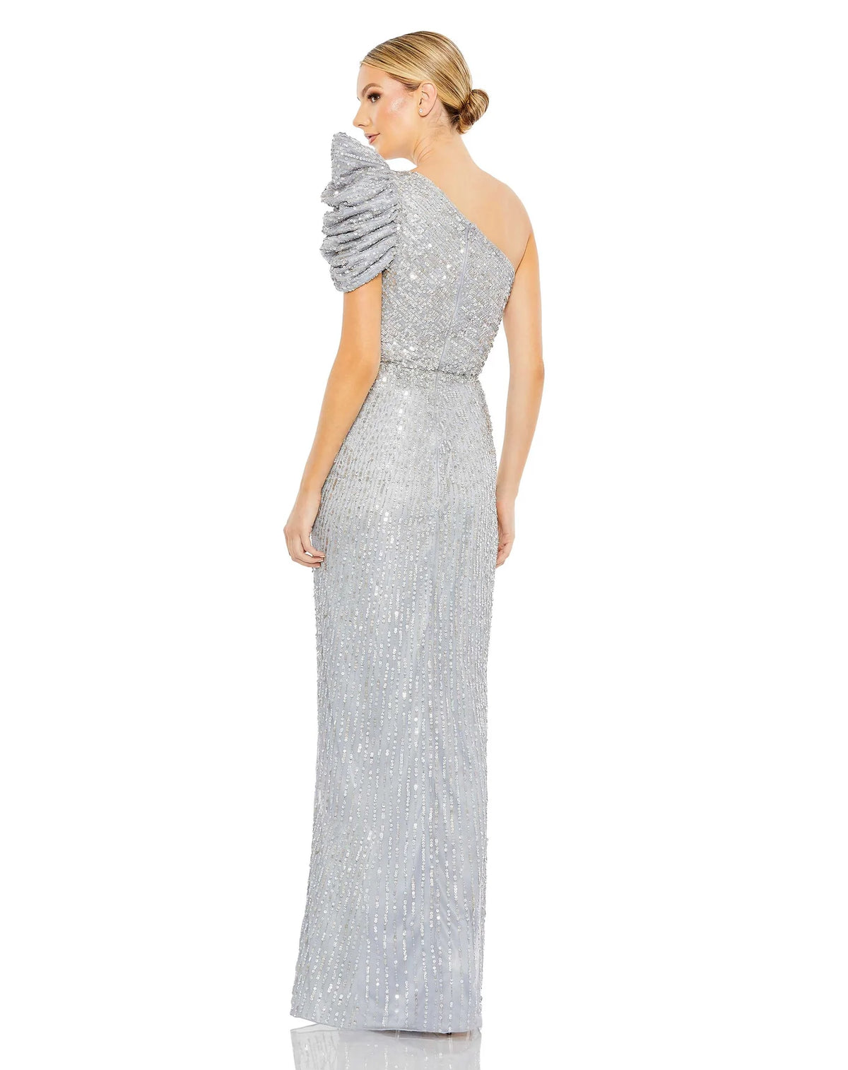 vThis beautiful silver sequin, one-shoulder, asymmetric floor-length, evening gown with a beautiful cinched waist and puff detail on the shoulder is an elegant gown for special occasions and events with one thigh high split and an elegant form-fitting fit back view
