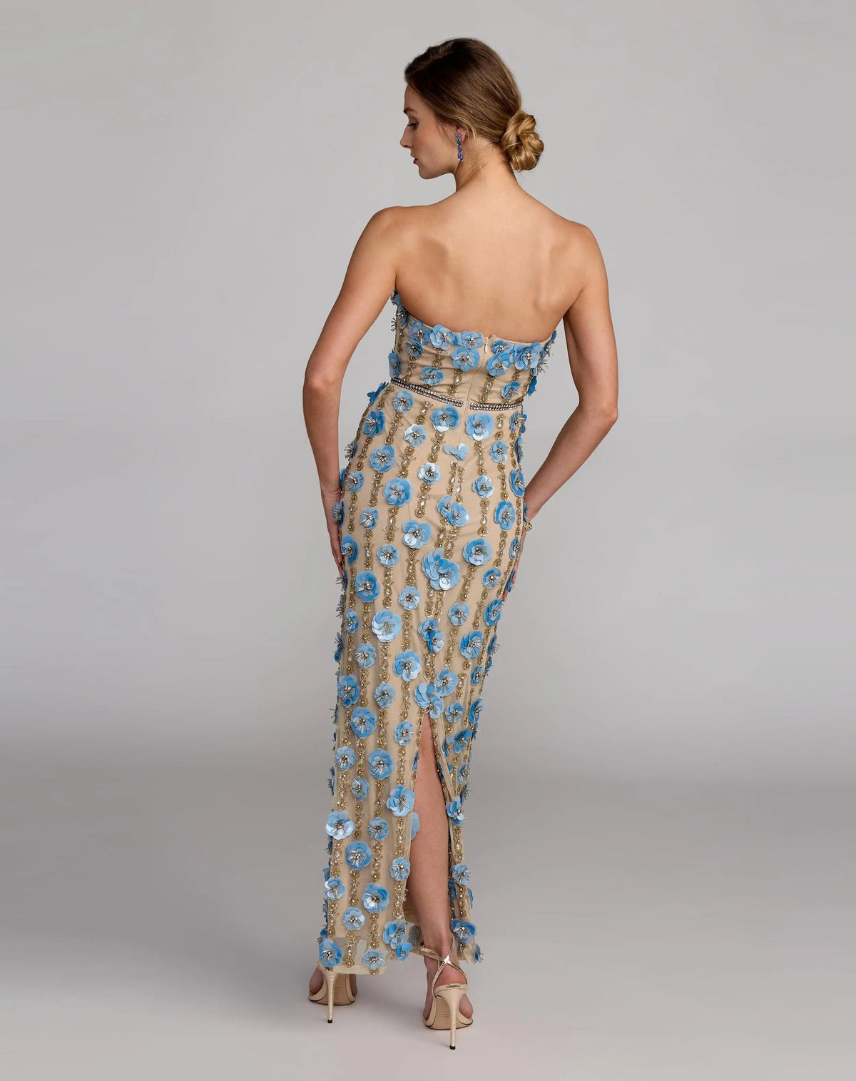 10128-NudeBlue-AB2 (1).jpg: Full-length back view of the strapless Nude Blue column gown featuring 3D floral paillettes and vertical gold beadwork.