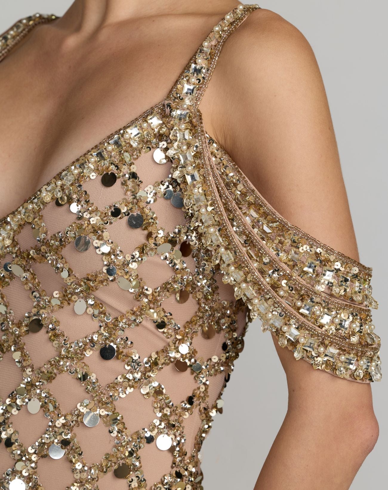 Close-up of a gold sequin dress with a gray background