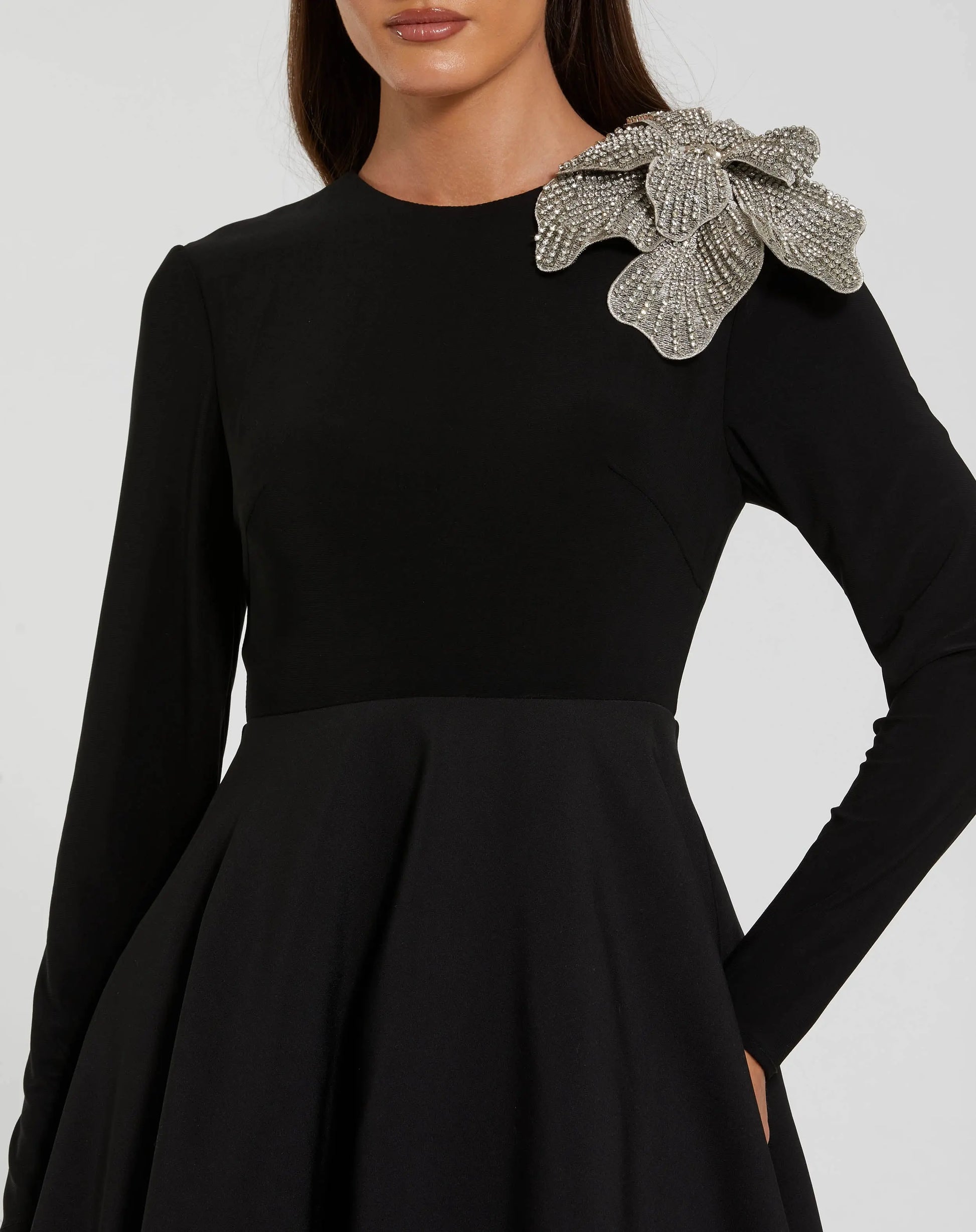 Black dress with floral embellishments on a white background