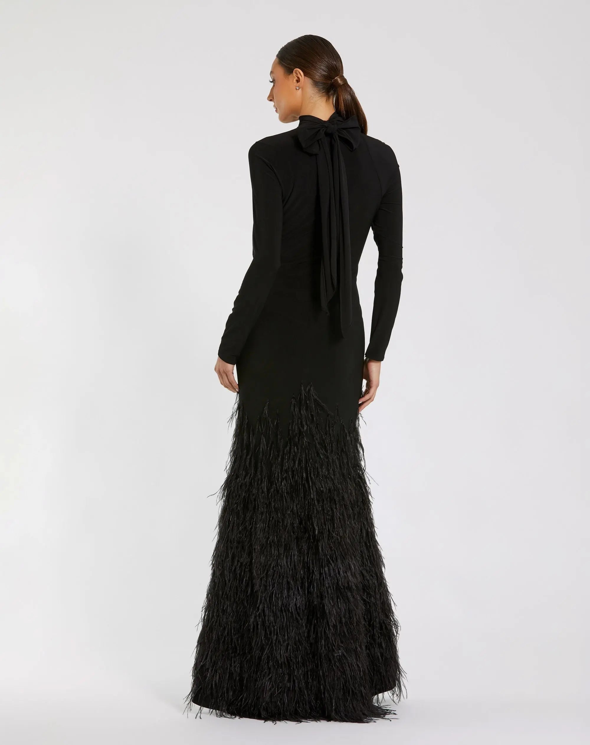 Black evening gown with feathered skirt on a white background