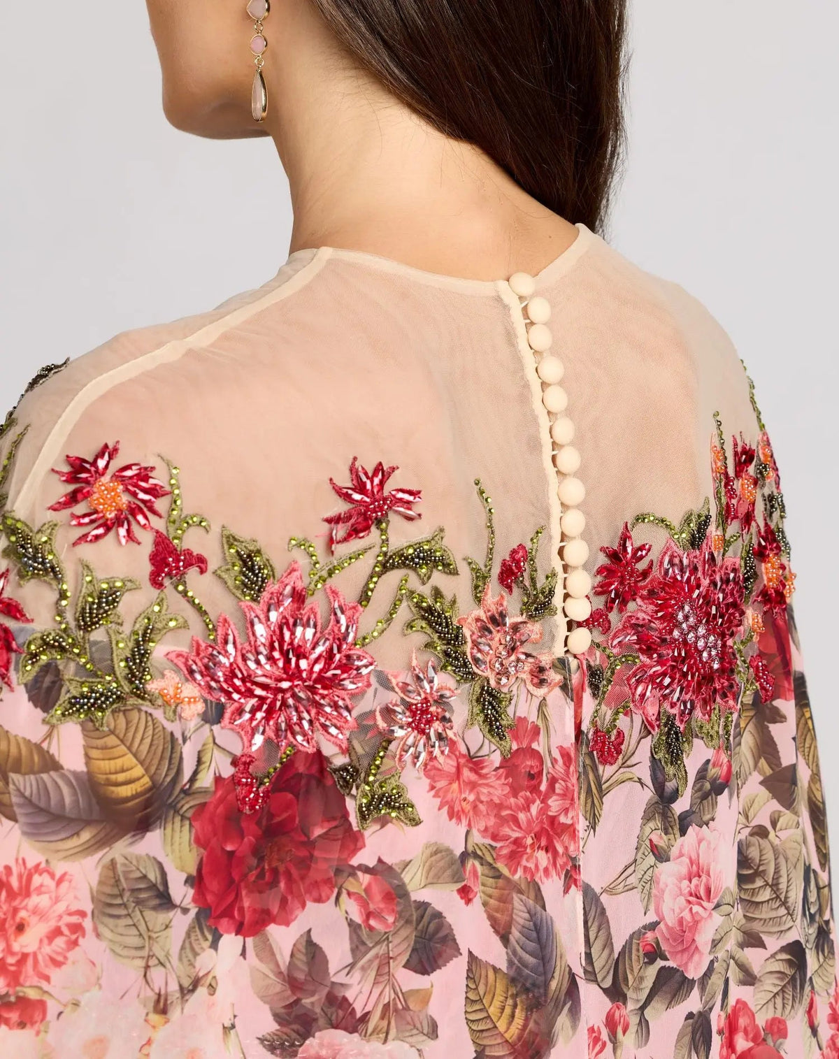 Detailed close-up of the back illusion neckline, button closure, and delicate floral beadwork.
