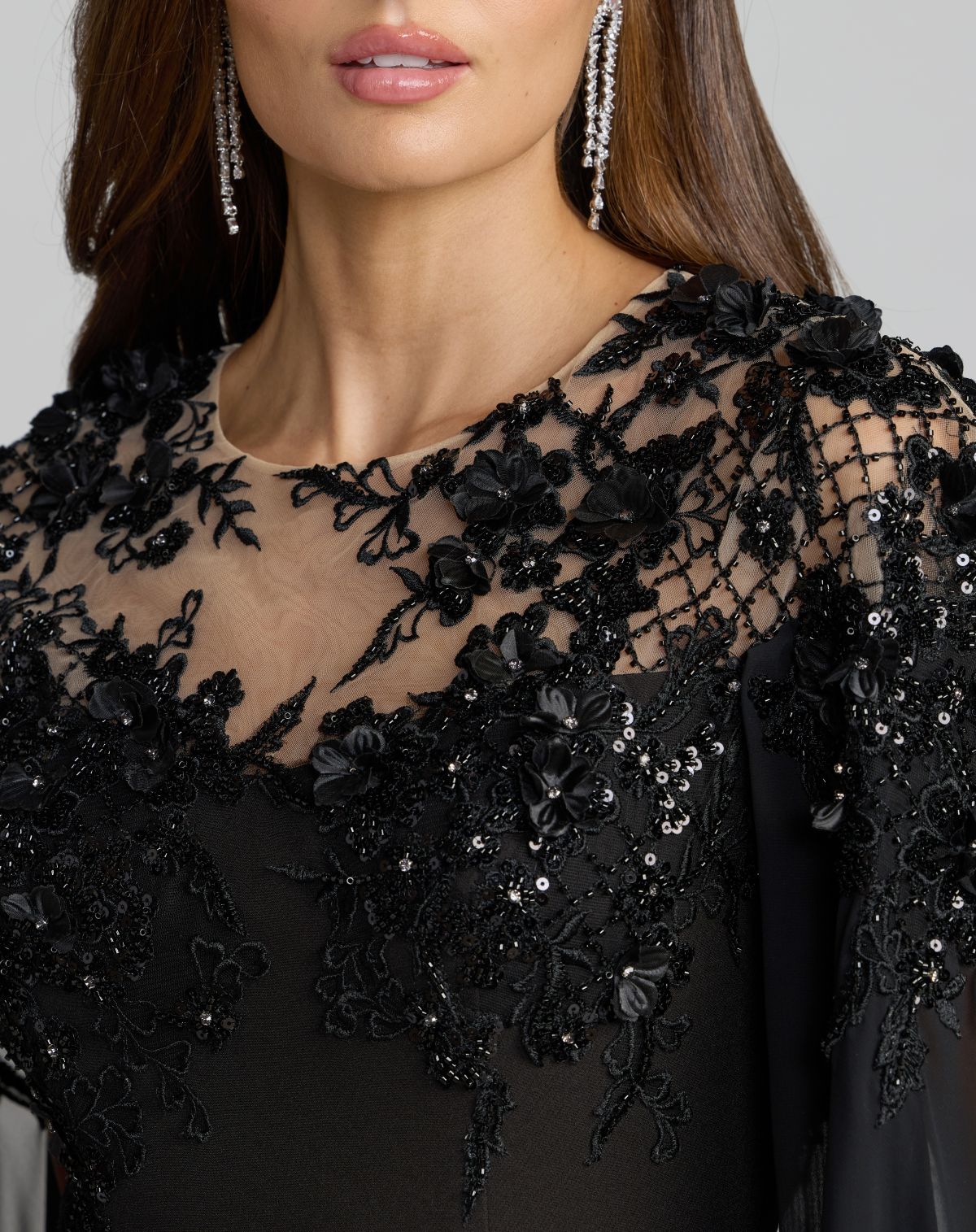 Close-up detail of floral embroidery, 3D floral accents, and sequin beadwork on the bodice of Mac Duggal 11954 black crepe gown