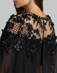 Close-up back view of Mac Duggal 11954 black gown showing button closure, embroidered bodice, and sheer cape sleeve construction