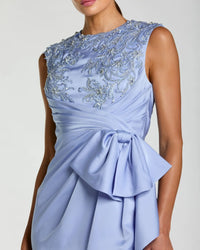 Light blue dress with intricate beading and a large bow on a plain background