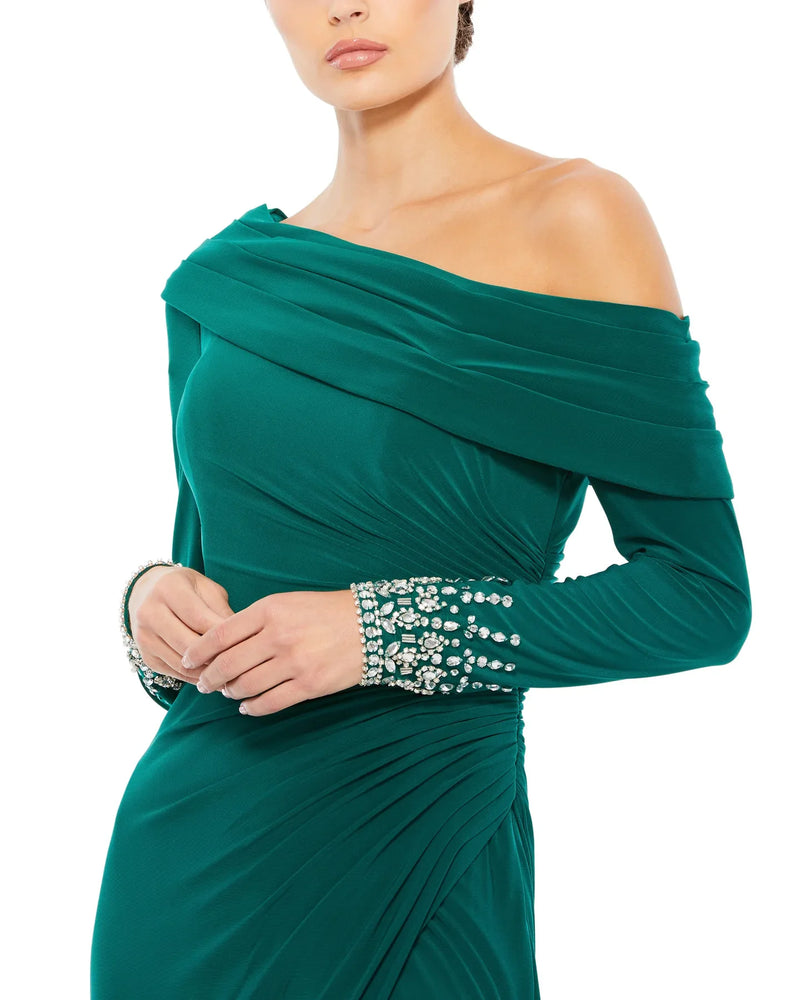 This stunningly elegant, floor-length, emerald green Mac Duggal, evening dress is a long sleeve jersey gown accented with jewelled cuffs and finished with a thigh-high slit! This bodycon, form-fitting evening gown is perfect for proms, black-tie affairs, weddings and special events close up