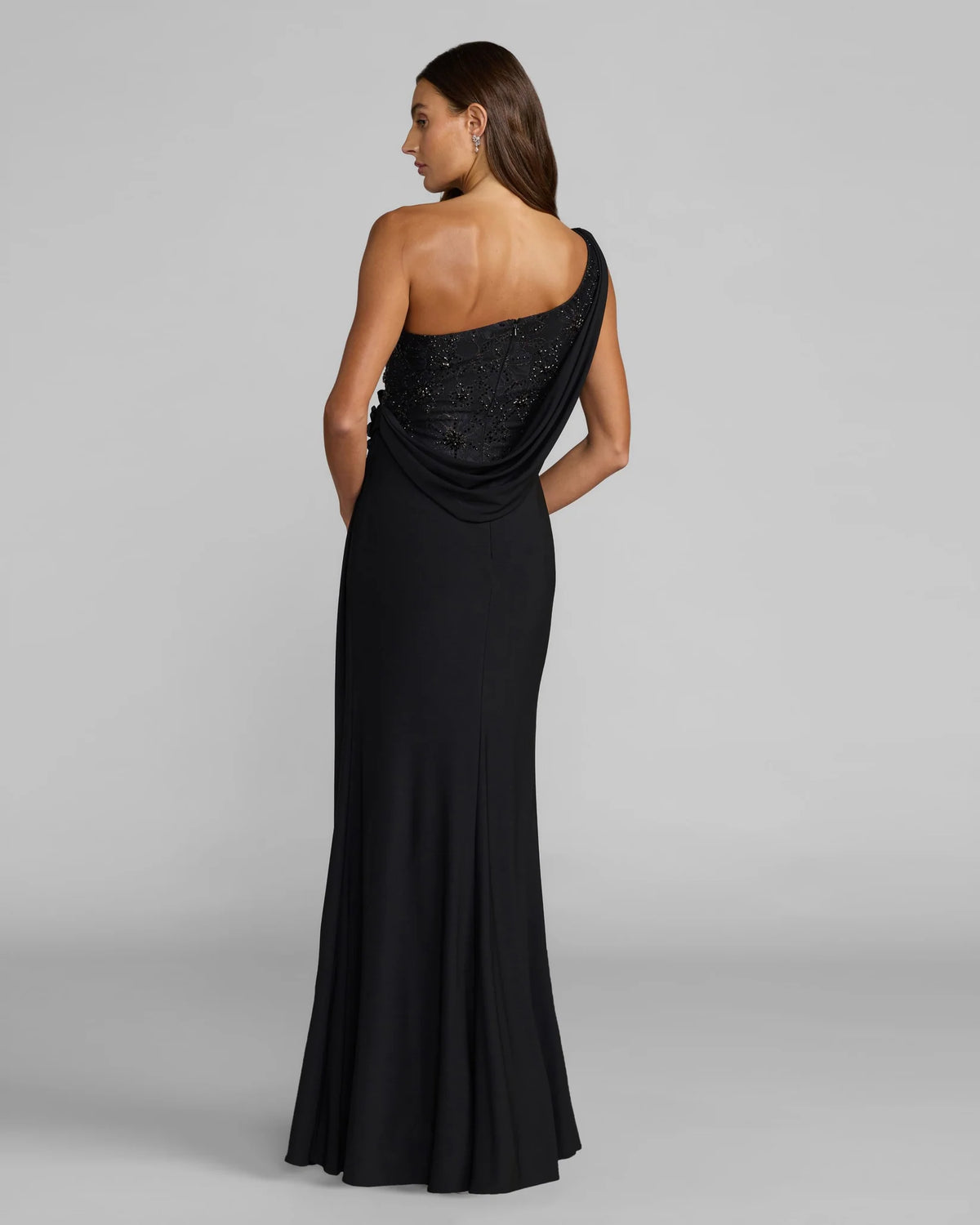 Back view of model wearing black asymmetric, grecian style, gown, style 13210, 