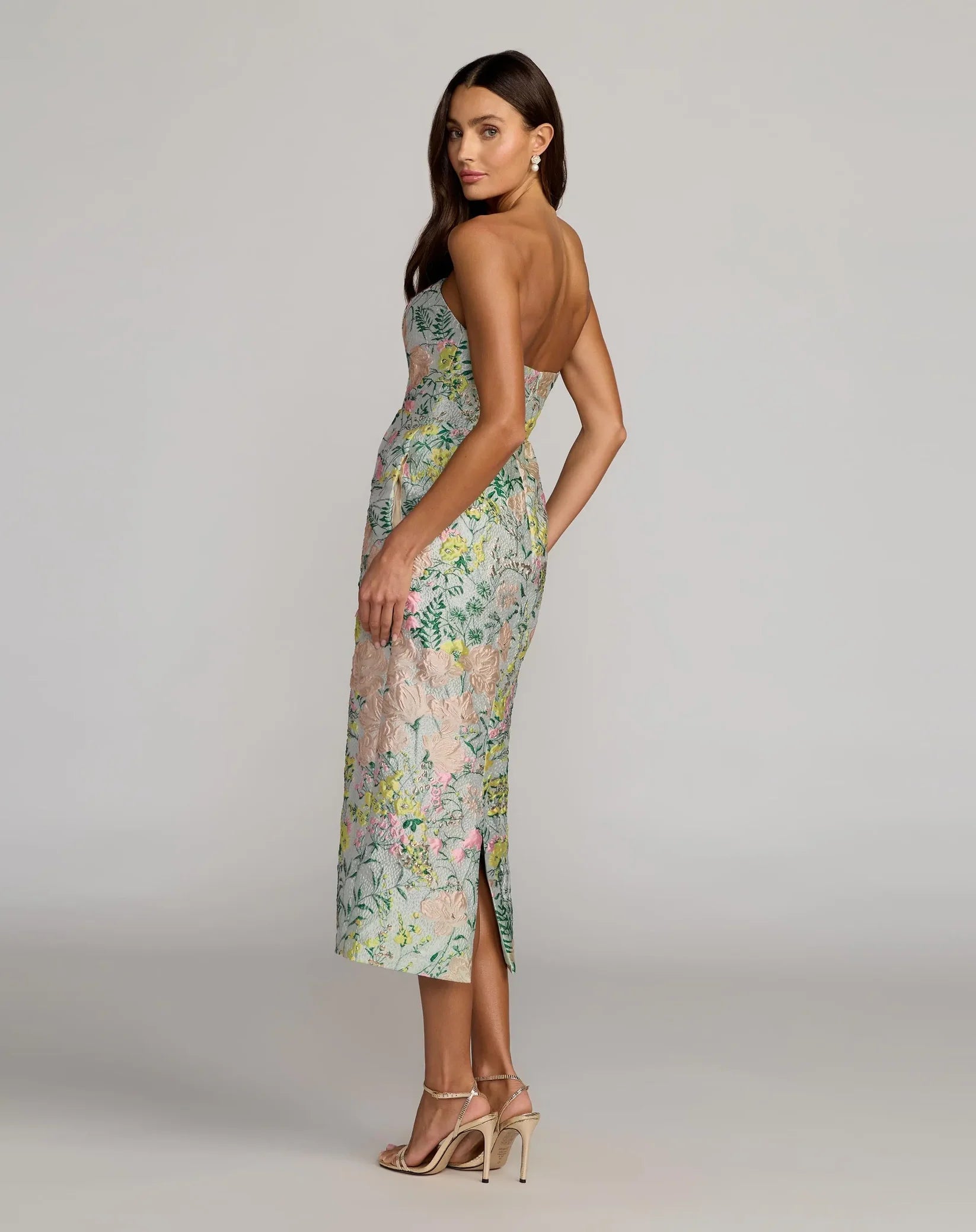 Woman wearing a floral dress on a gray background