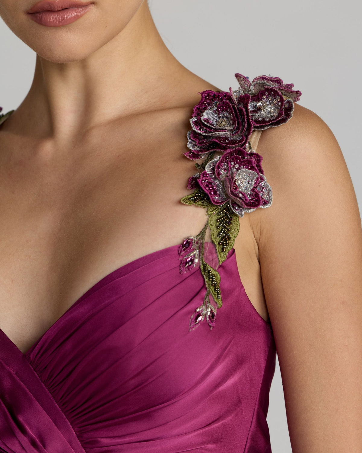 Full-length lifestyle studio shot of a model wearing the magenta satin high-low A-line gown.
