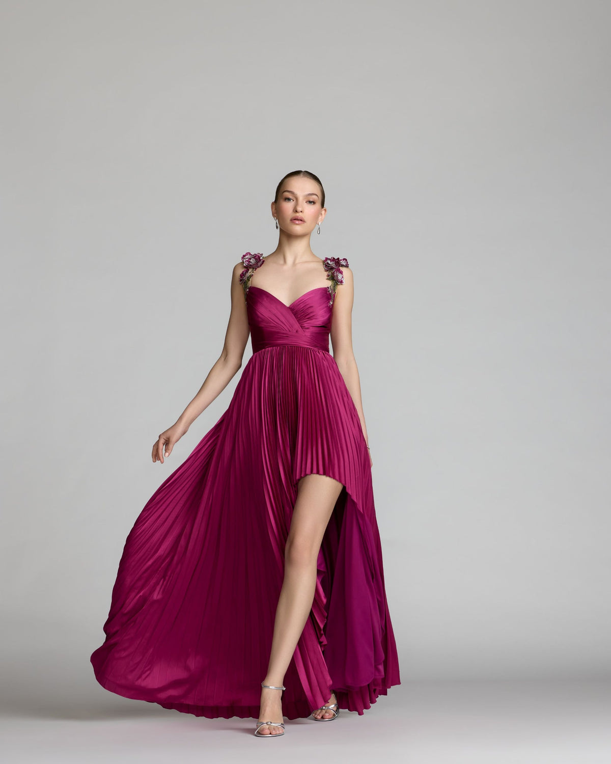 Close-up shot showing the detail of the sweetheart neckline and floral embroidered straps on a magenta gown.