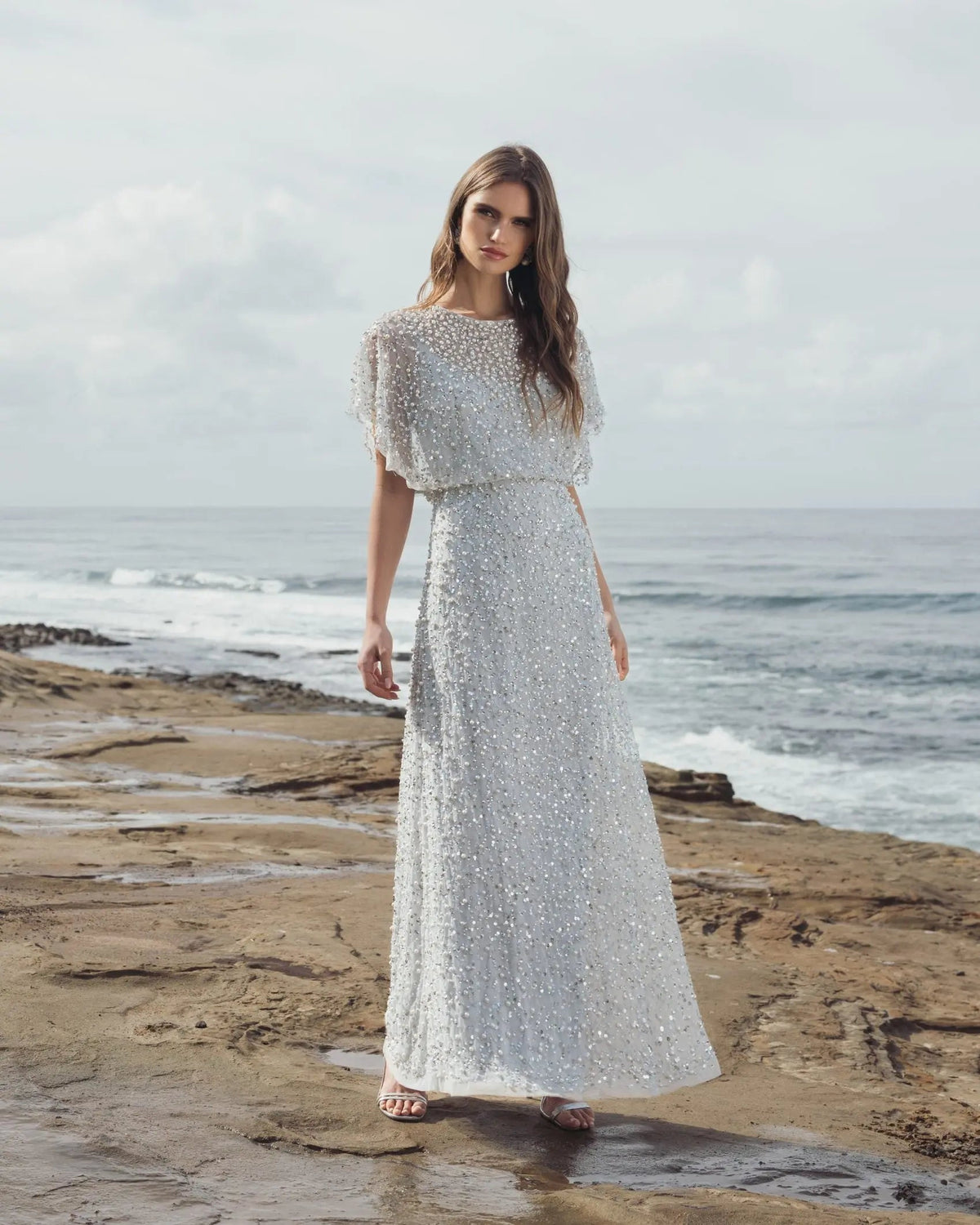 Side profile lifestyle view emphasizing the sheer mesh short sleeves and the regal silhouette of the cape details.