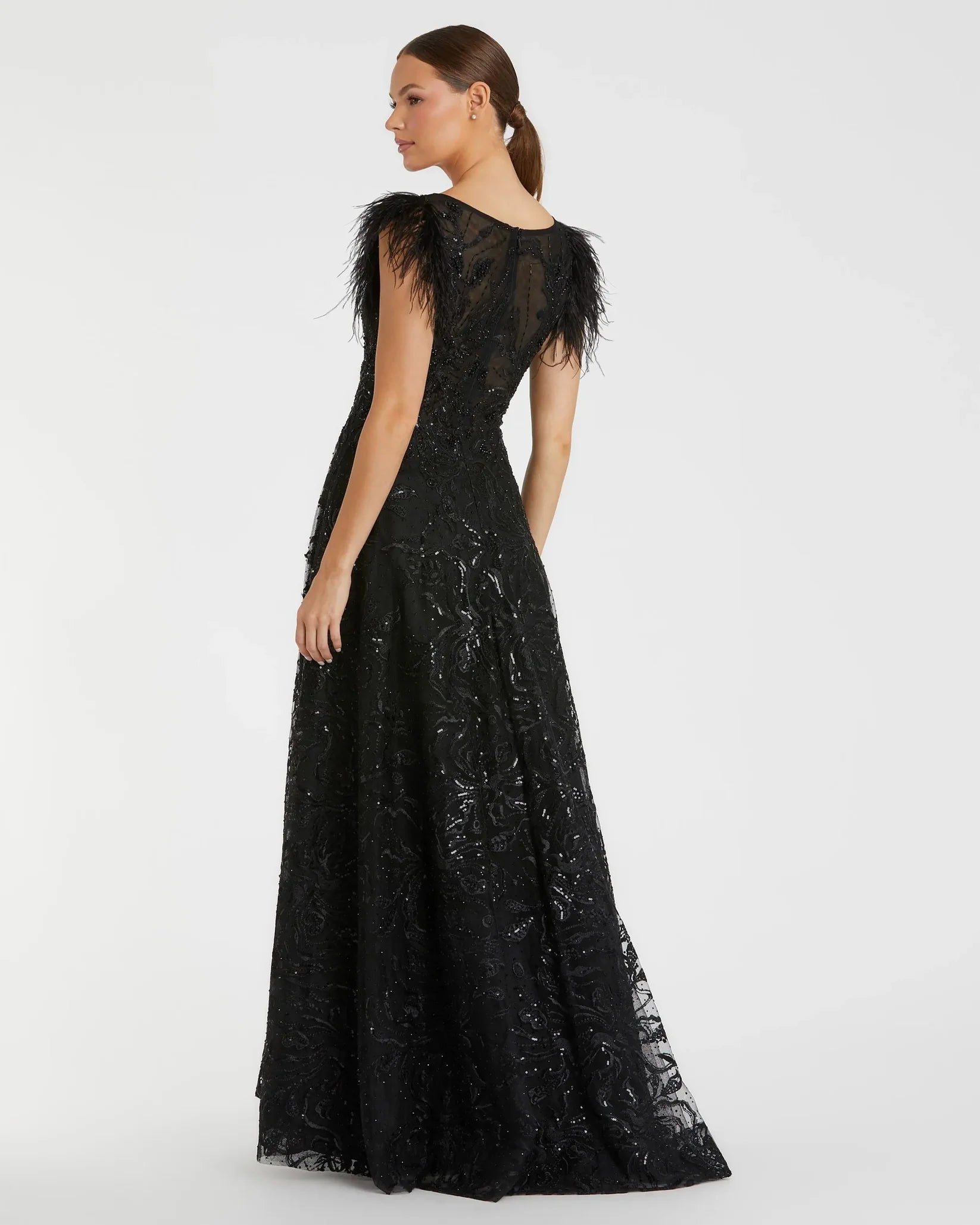 Black lace evening gown with feather details on a white background