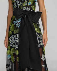 Close up the bow of model wearing Mac Duggal Black Floral Embroidered Corset Gown With Bow #21058 Blue Multi