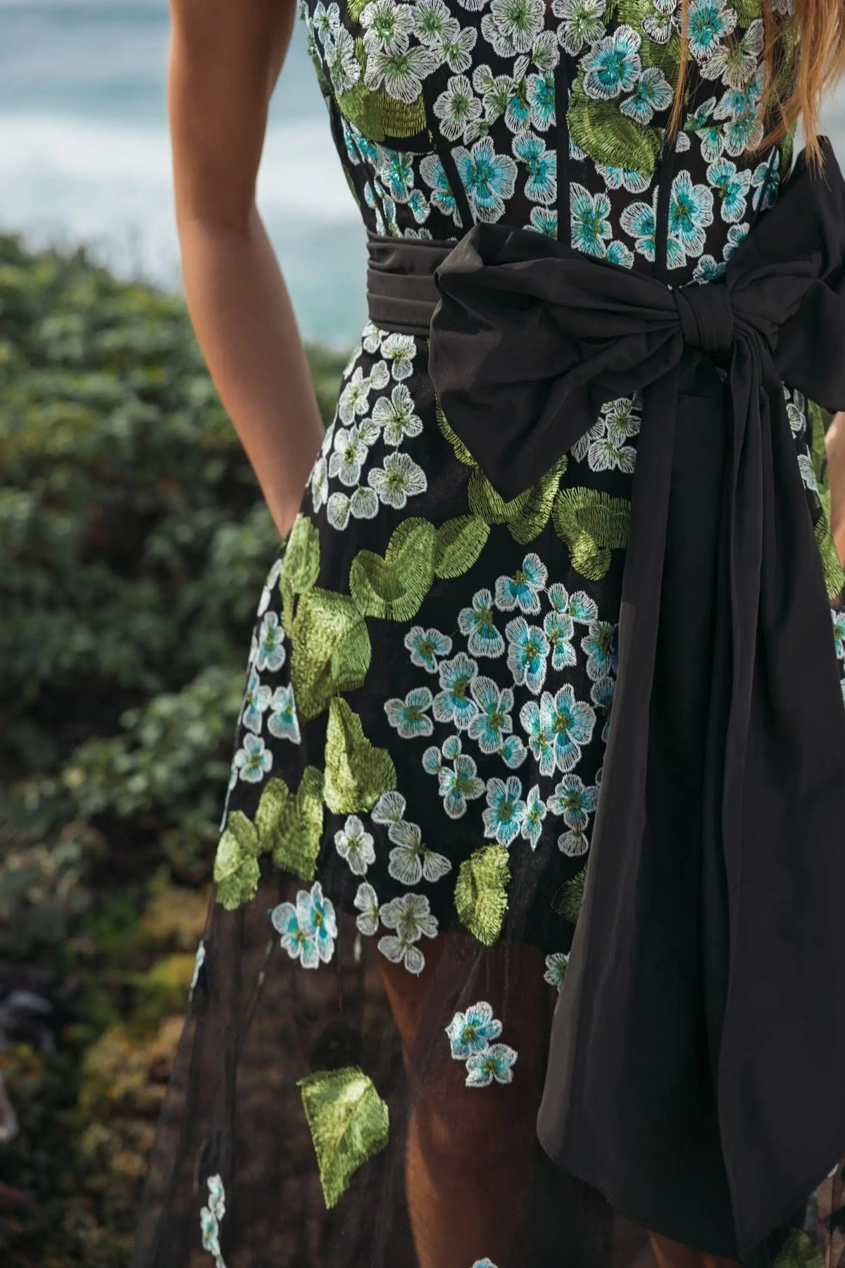 Editorial shot of the back of the dress Mac Duggal Black Floral Embroidered Corset Gown With Bow #21058 Blue Multi