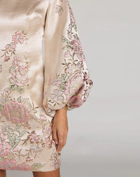 Beige dress with floral embroidery on a plain background