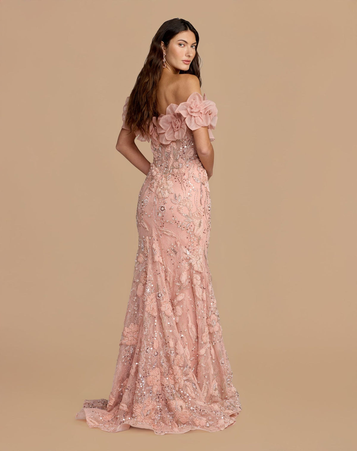 Back view of a model in a blush mermaid gown with textured 3D rosettes and intricate beading.