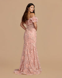 Back view of a model in a blush mermaid gown with textured 3D rosettes and intricate beading.