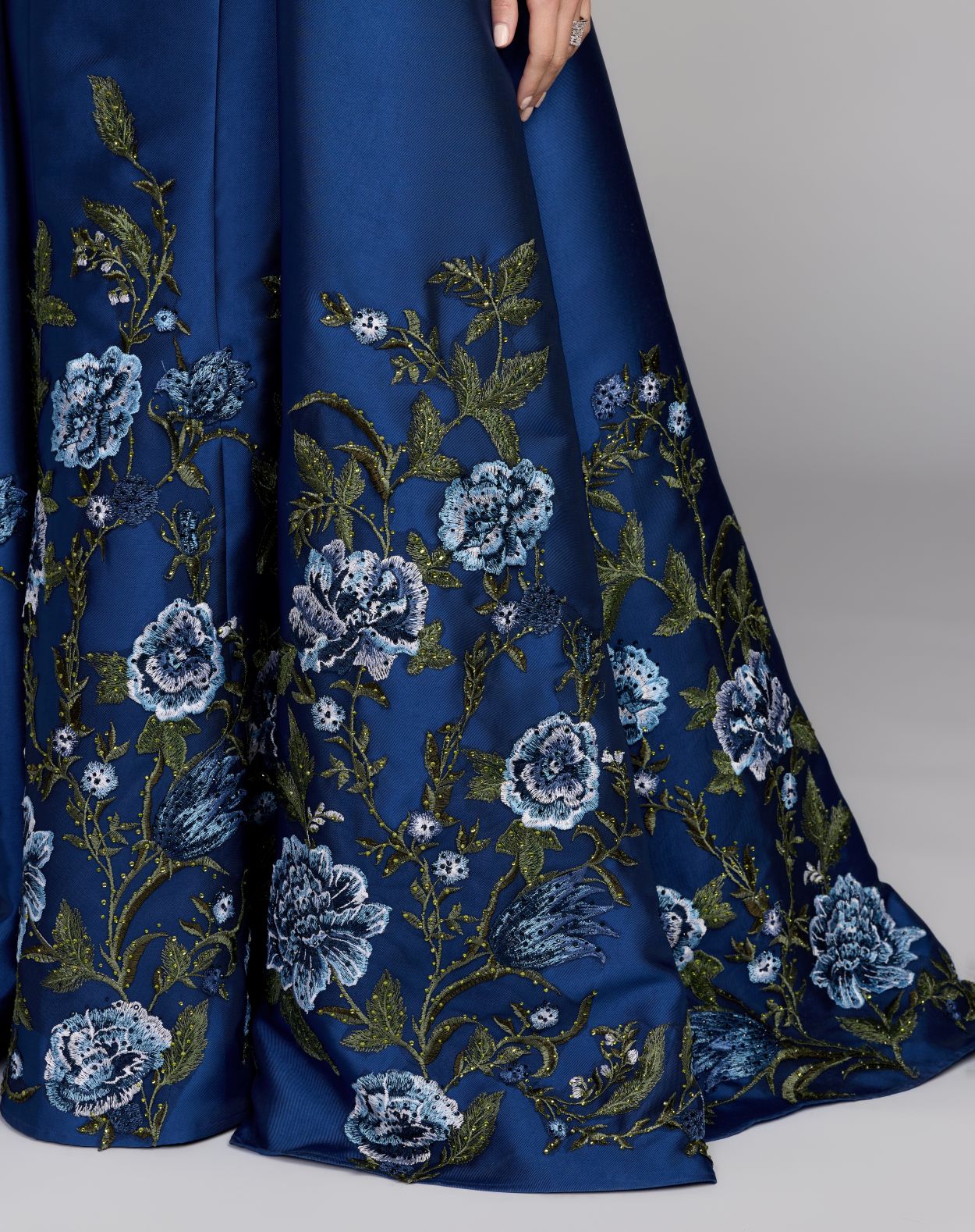 Navy blue fabric with floral embroidery on a gray background
