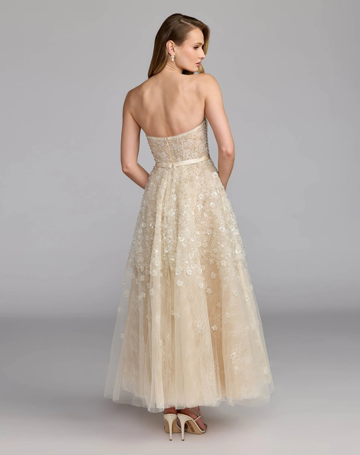 Back view of the Oyster formal dress highlighting the structured lace corset pattern, zip closure, and full A-line skirt.