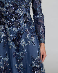 Navy blue evening gown with floral and sequin embellishments on a neutral background