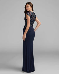Navy evening gown with floral lace top on a gray background