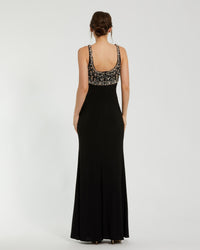 Black evening gown with floral embellishments on a white background