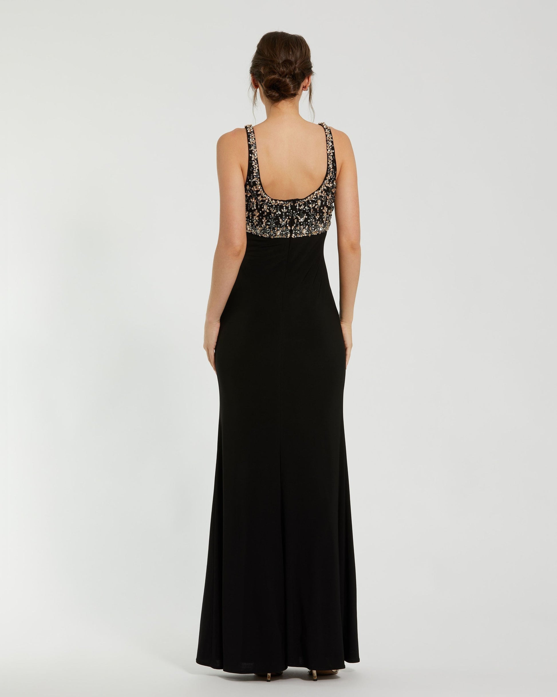 Black evening gown with floral embellishments on a white background