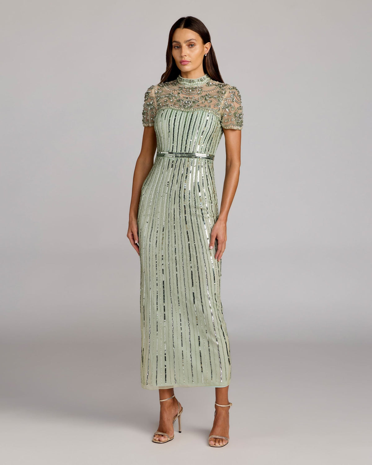 Model posing in Mac Duggal 23075 light sage embellished midi dress