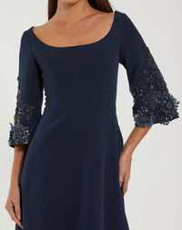 Navy blue dress with embellished sleeves on a white background