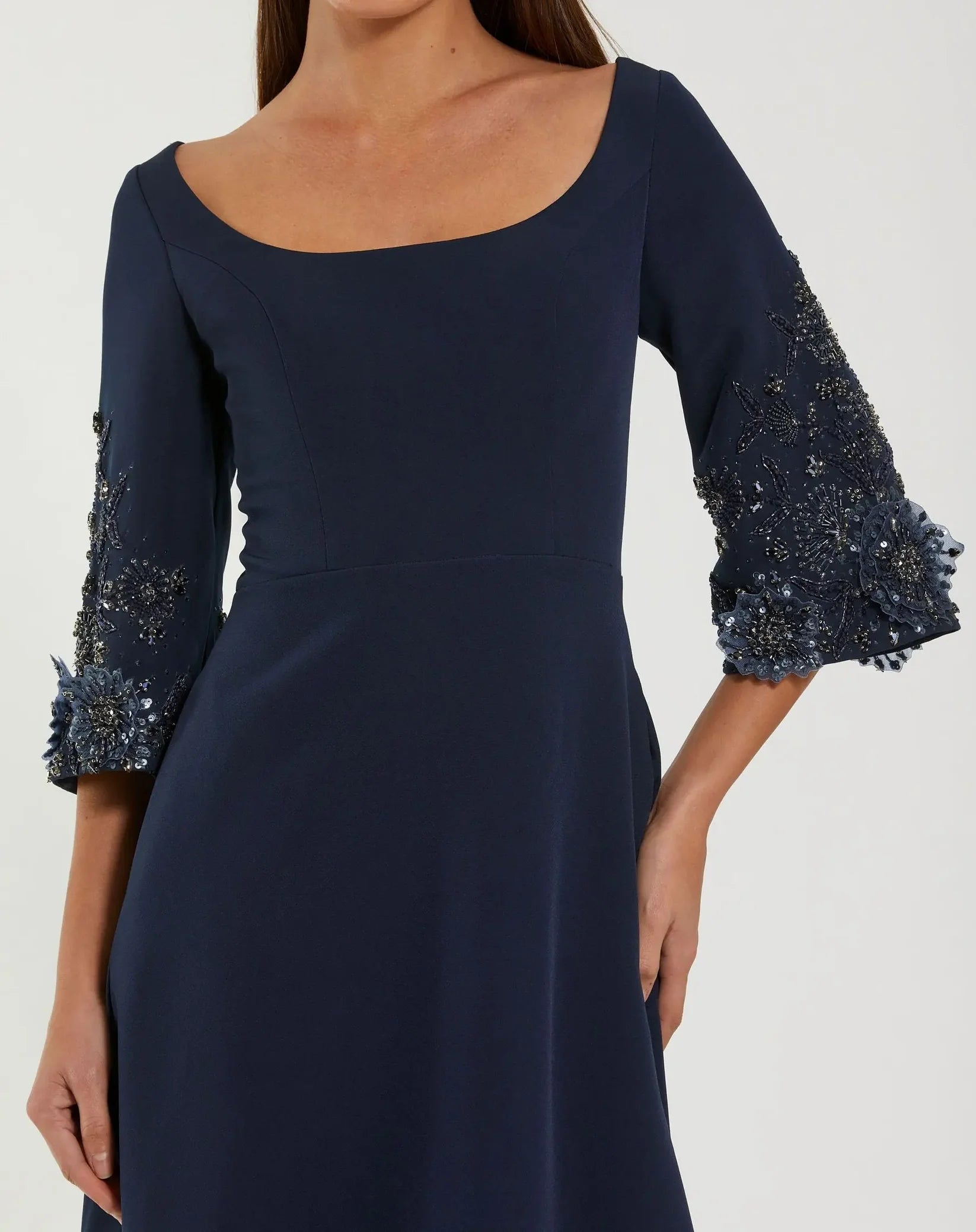 Navy blue dress with embellished sleeves on a white background