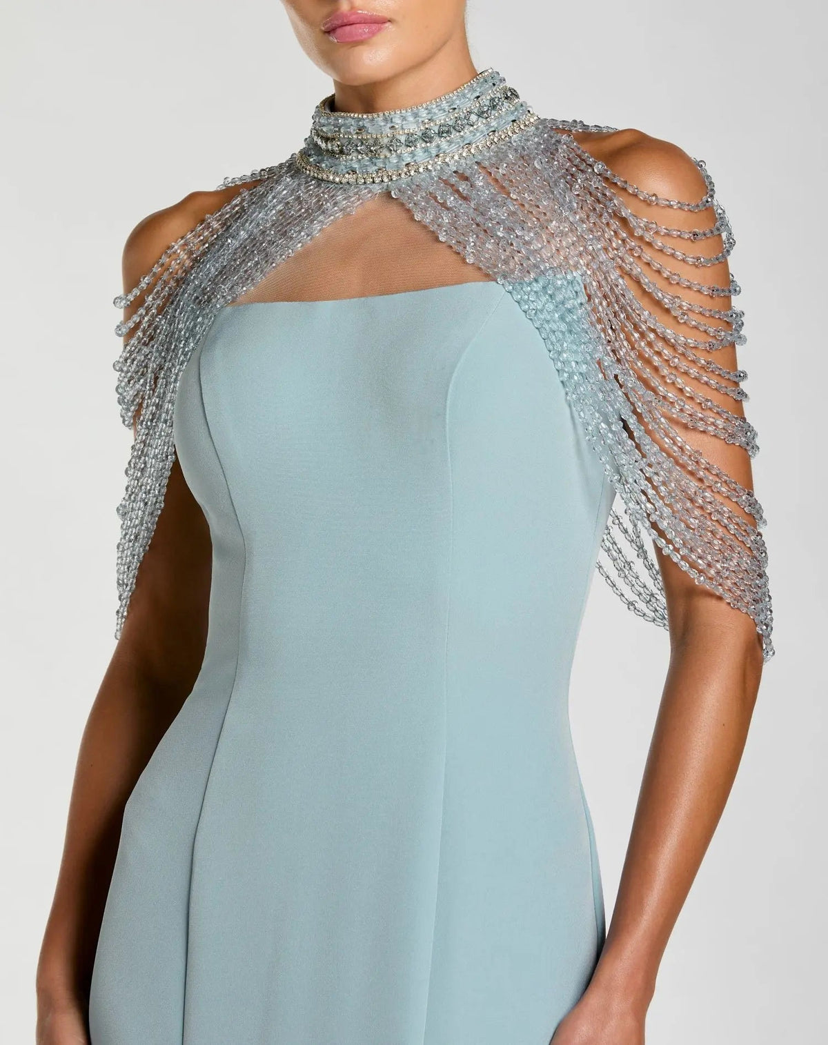 Close-up of the intricate embellished illusion halter neck and hanging crystal shoulder drapes on the French Blue formal gown.