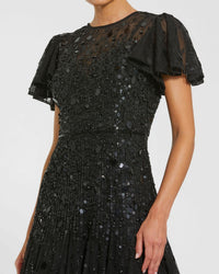 Black sequin dress with sheer sleeves on a white background