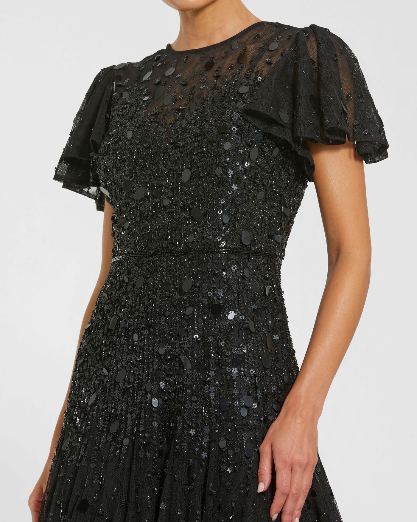 Black sequin dress with sheer sleeves on a white background