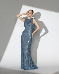 Woman wearing a blue sequin gown against a white background