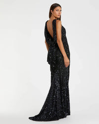 Woman wearing a black sequin gown on a white background