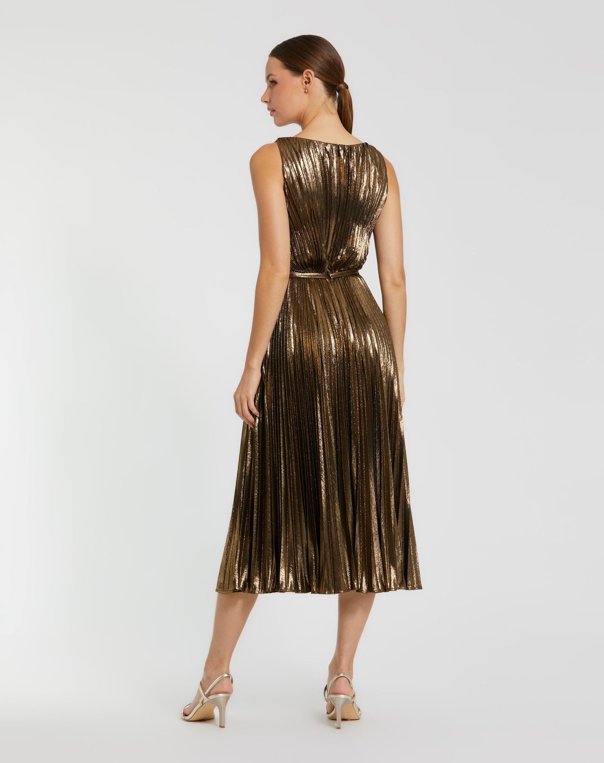 Woman wearing a gold metallic dress on a white background