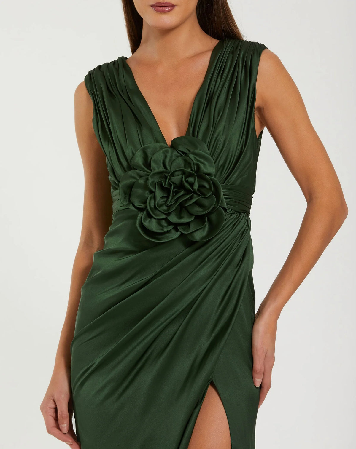 Green evening gown with a large floral detail on a white background