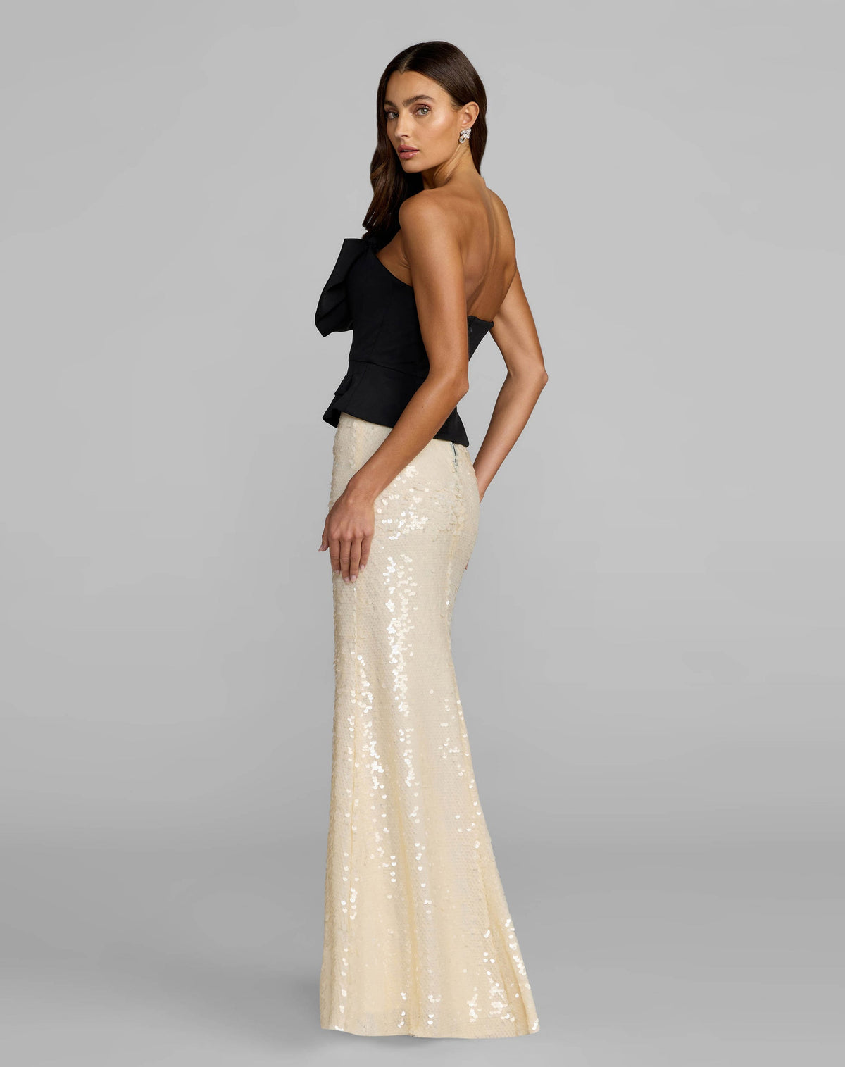 Side view of model wearing the Mac Duggal Black and Ivory Strapless Peplum Sequin Evening Gown #27793