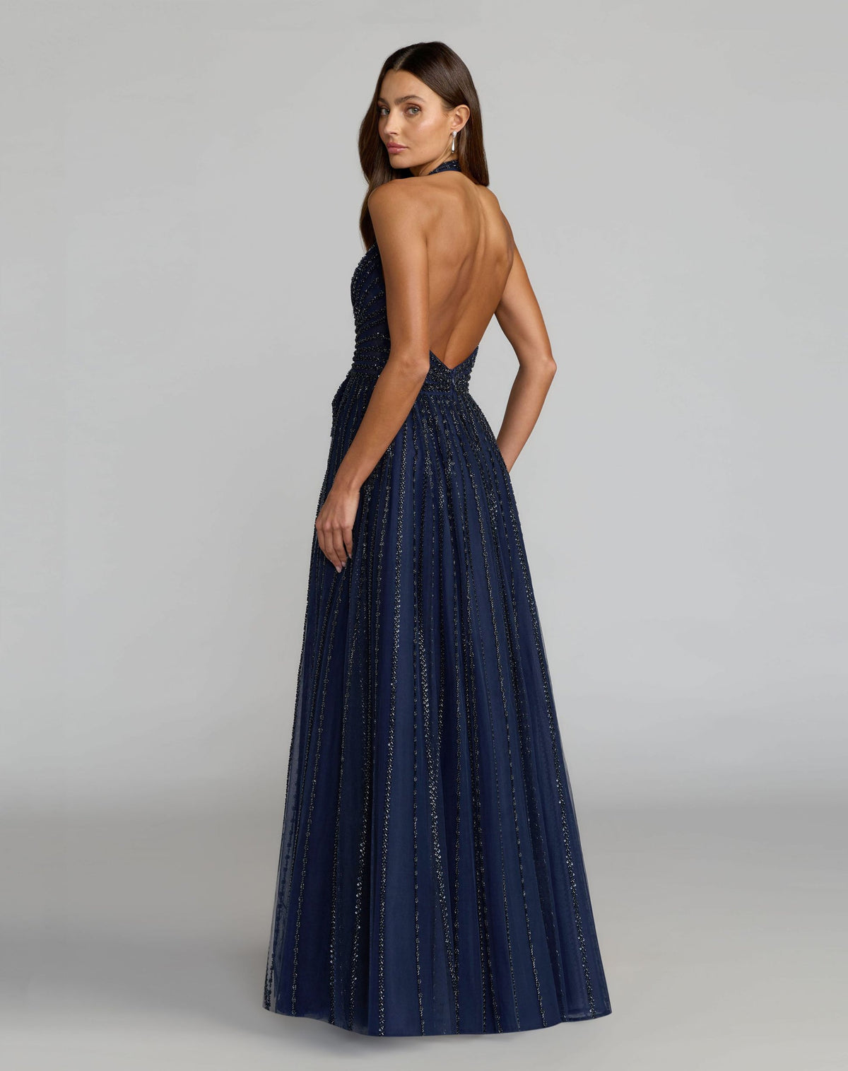 Back view of model in Mac Duggal 37120 midnight open-back gown with beaded tulle
