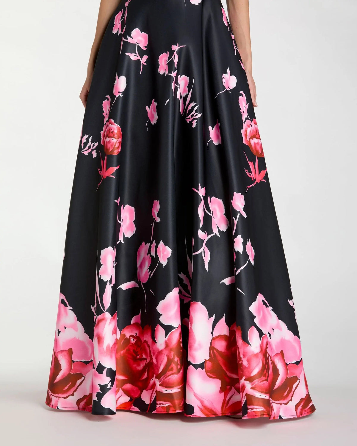 close up of bottom of the dress showcasing the floral embroidery on the black satin fabric