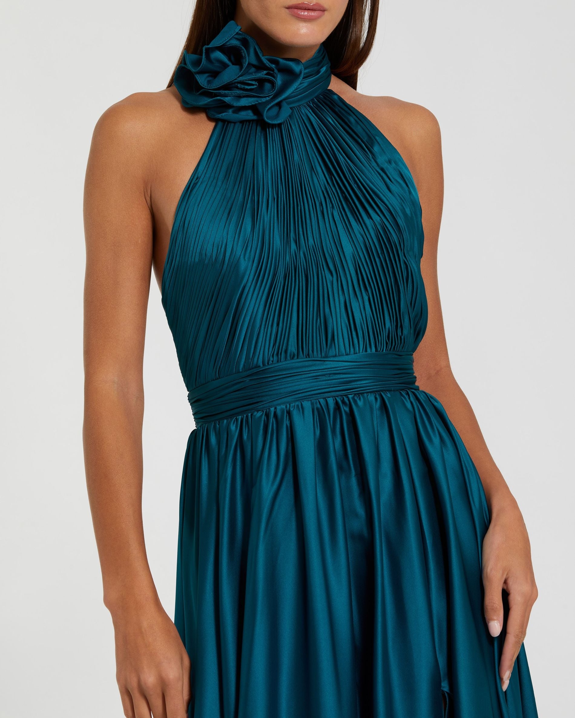 Teal halter neck dress with floral detail on a white background
