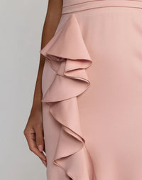 Close-up of a pink ruffled dress on a plain background