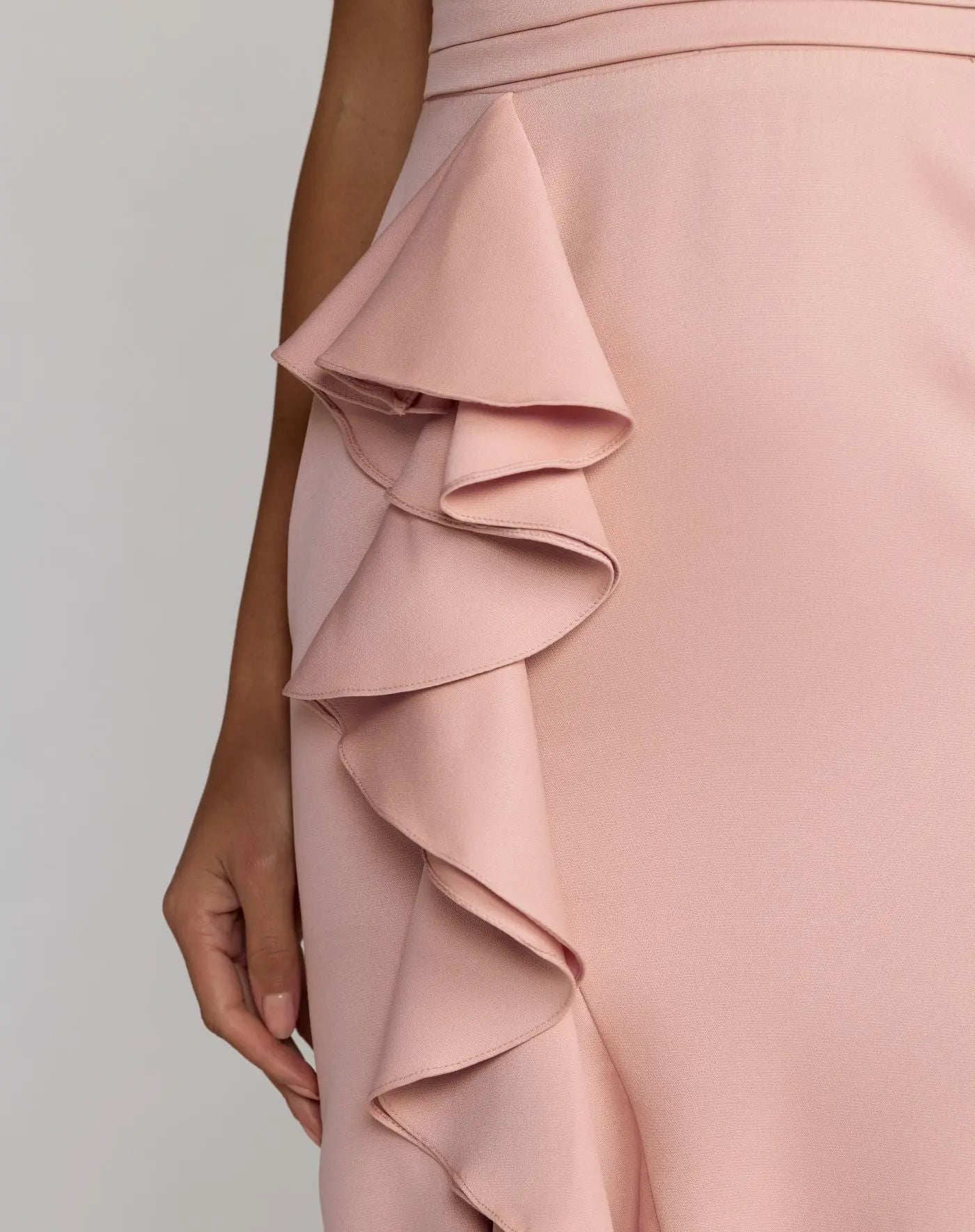 Close-up of a pink ruffled dress on a plain background