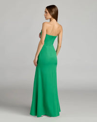 Woman wearing a strapless green evening gown on a gray background