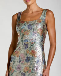 Woman wearing a floral sequin dress against a neutral background