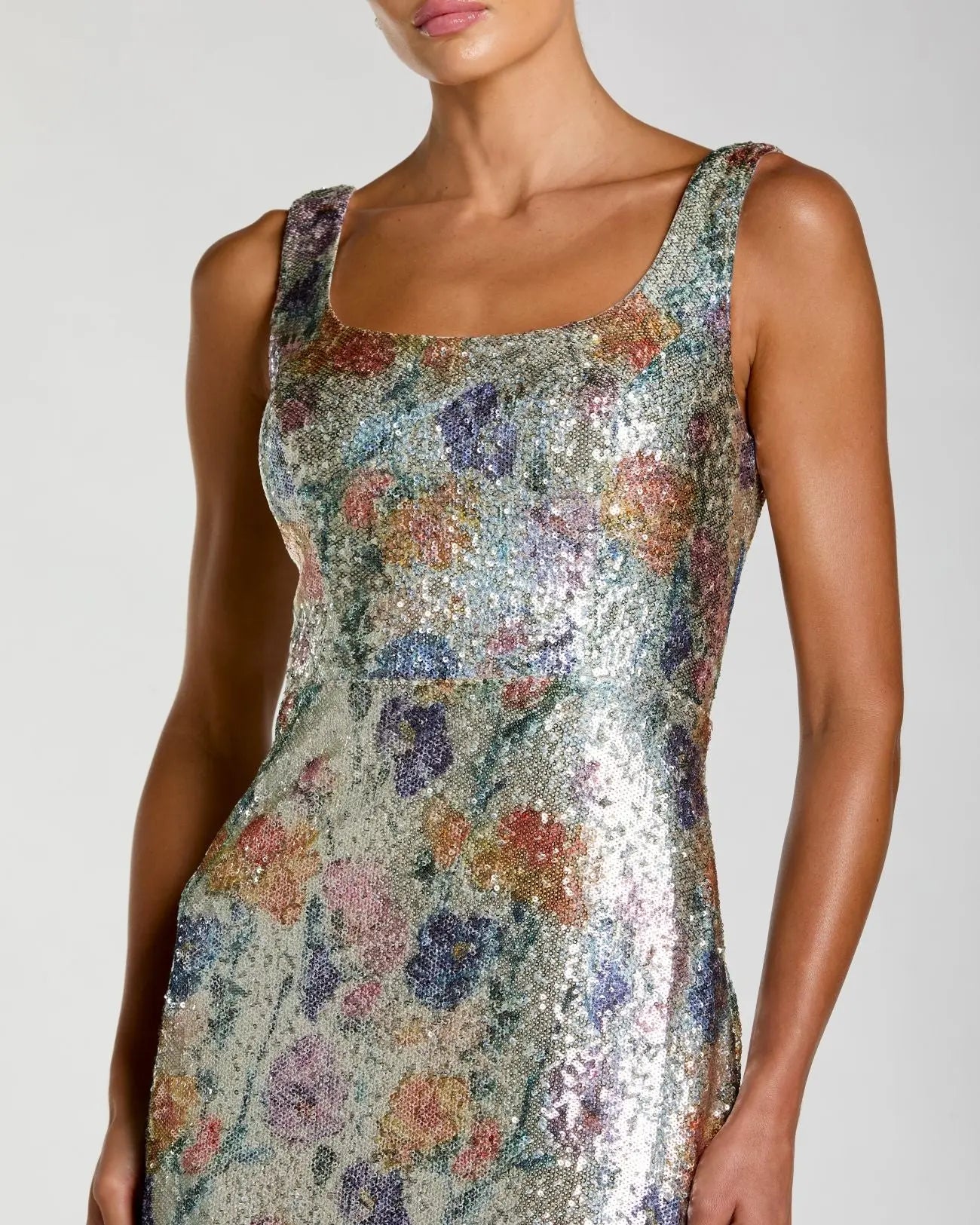Woman wearing a floral sequin dress against a neutral background