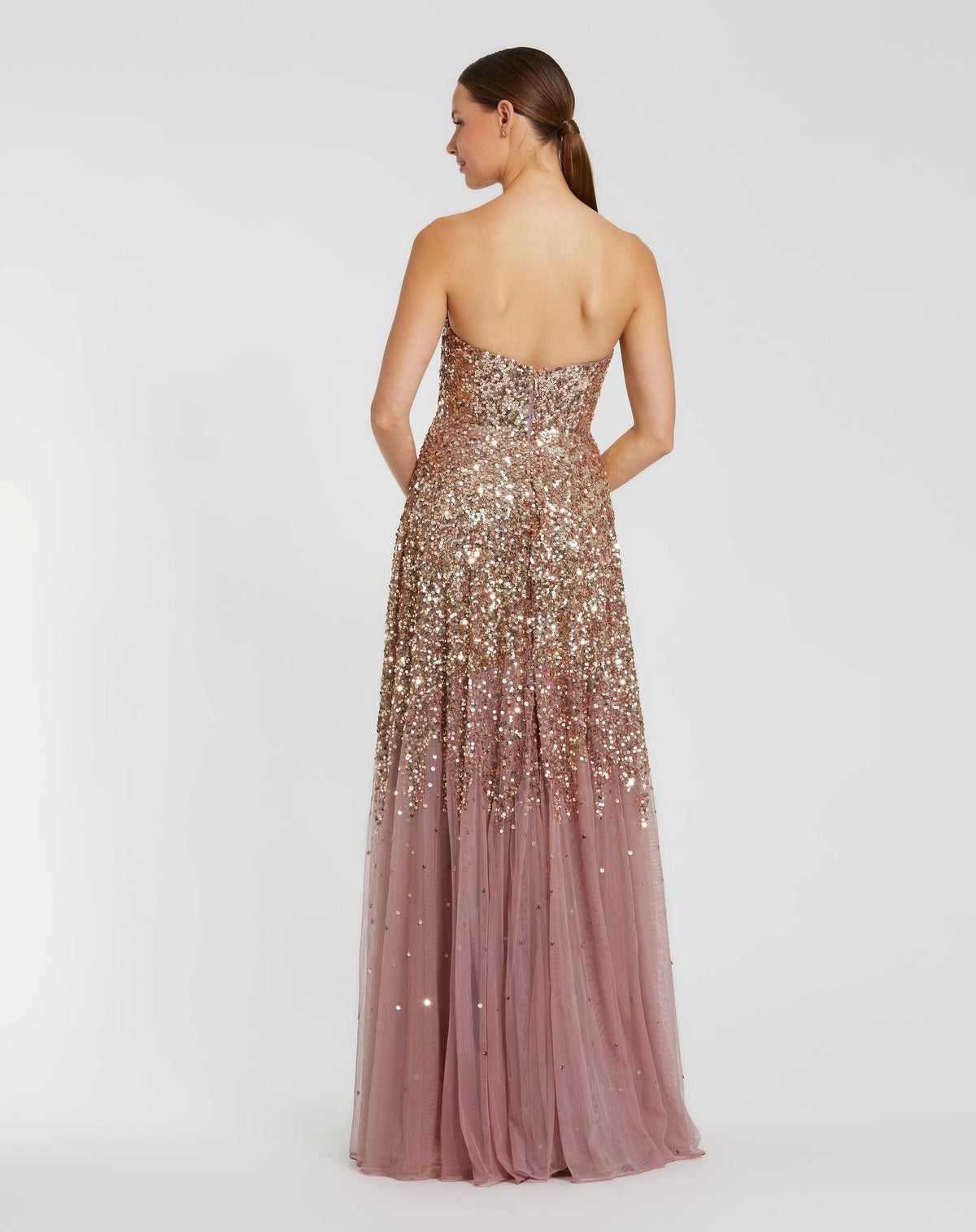 Back view of a model in a Gold Amethyst strapless sequin gown, showing the A-line silhouette and back zipper.
