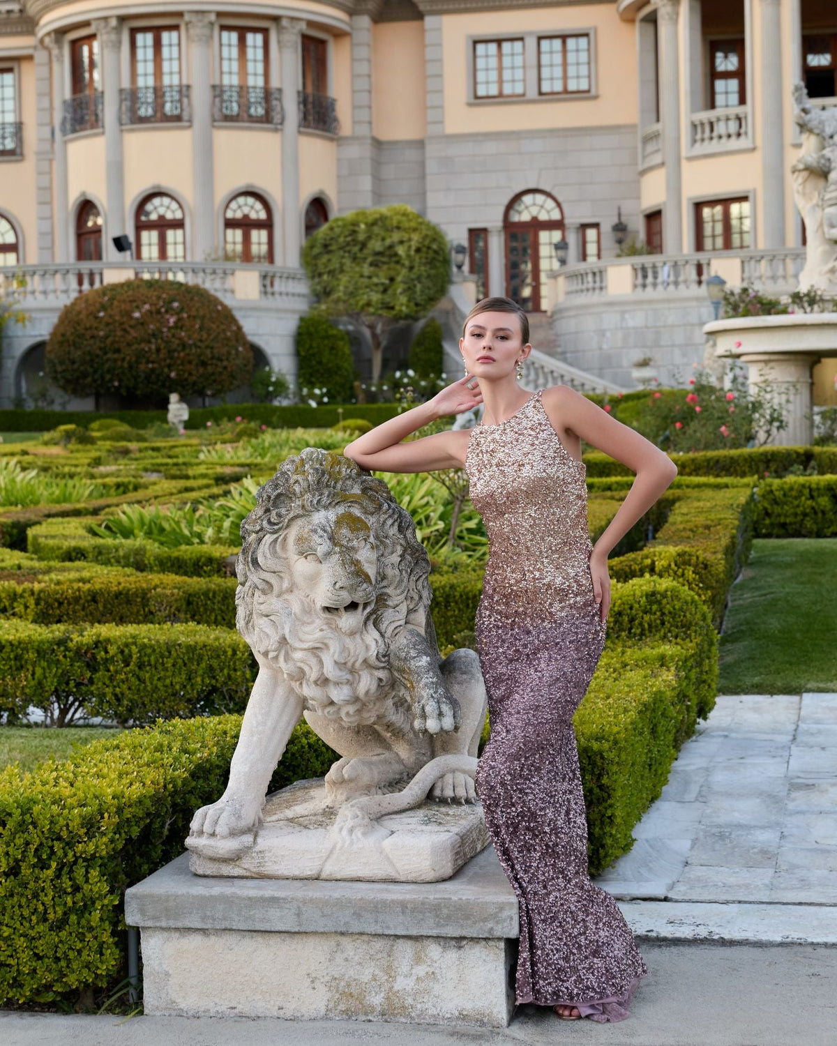 Back view of a model in a Gold Amethyst ombré sequin gown showing the cowl back design.