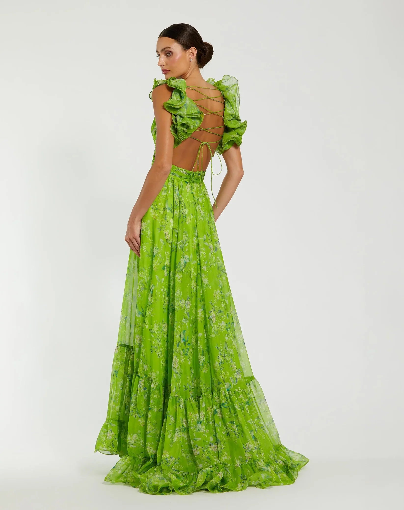 Woman wearing a green dress with ruffled top on a white background